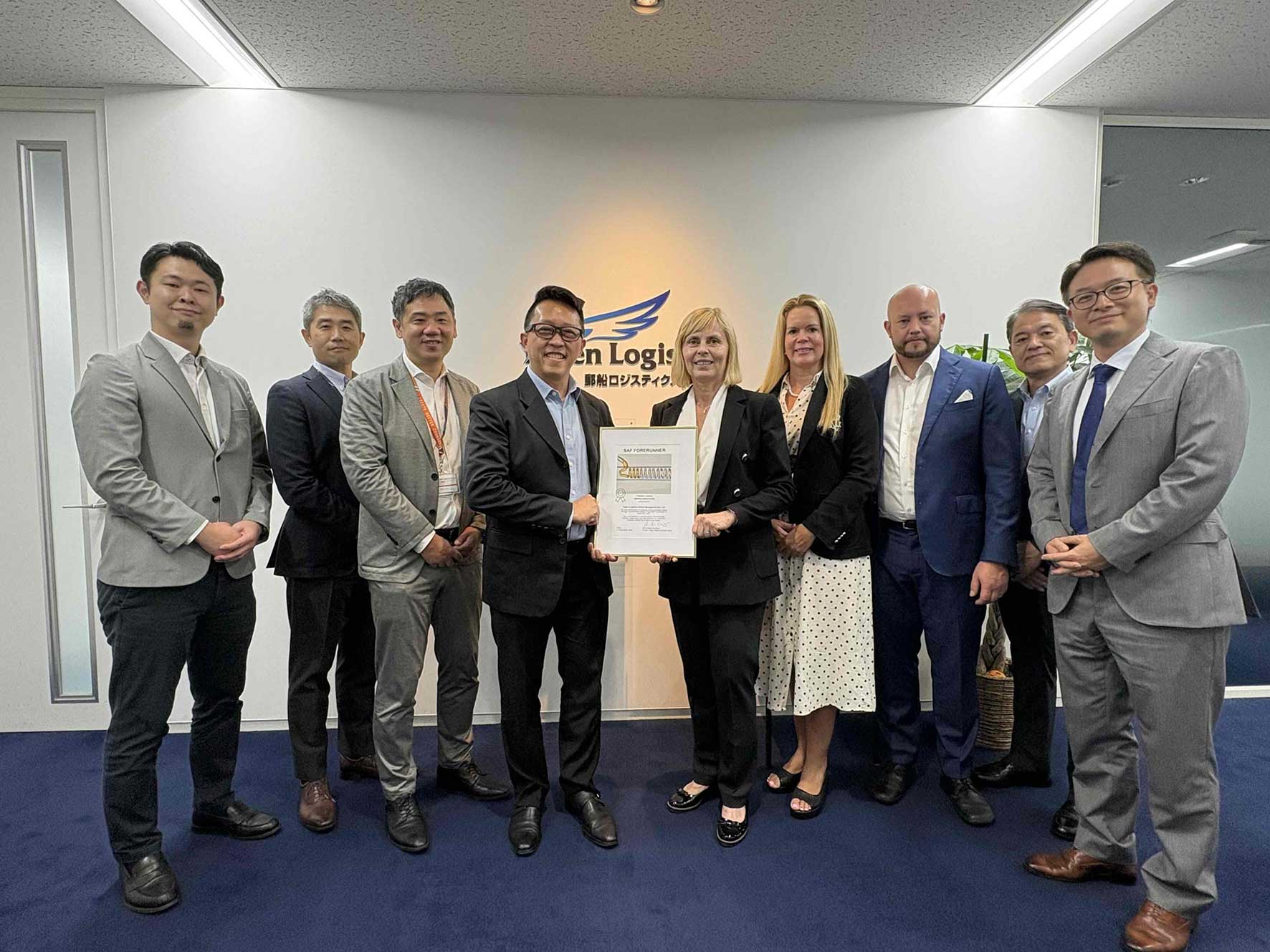 Representatives from Yusen Logistics and Finnair gather for a photograph holding a sustainable aviation fuel agreement certificate.