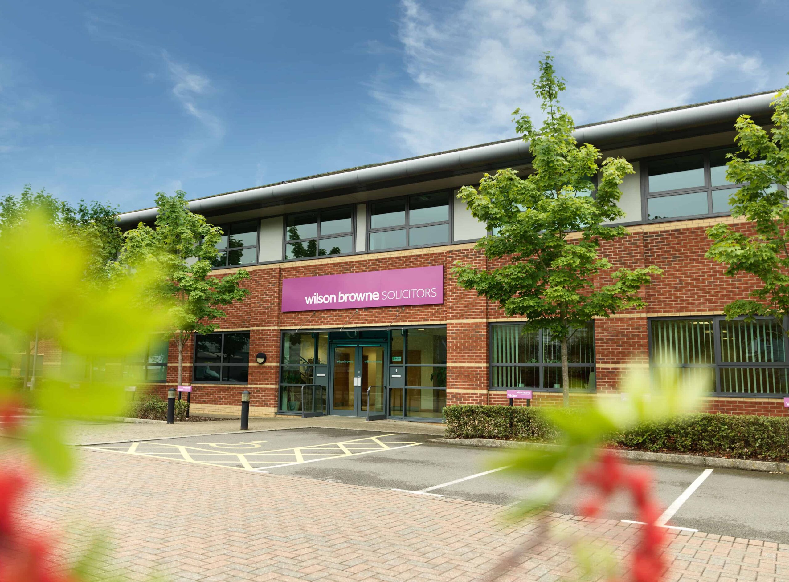 Exterior of a Wilson Browne Solicitors office, with the firm's purple signage above the entrance.